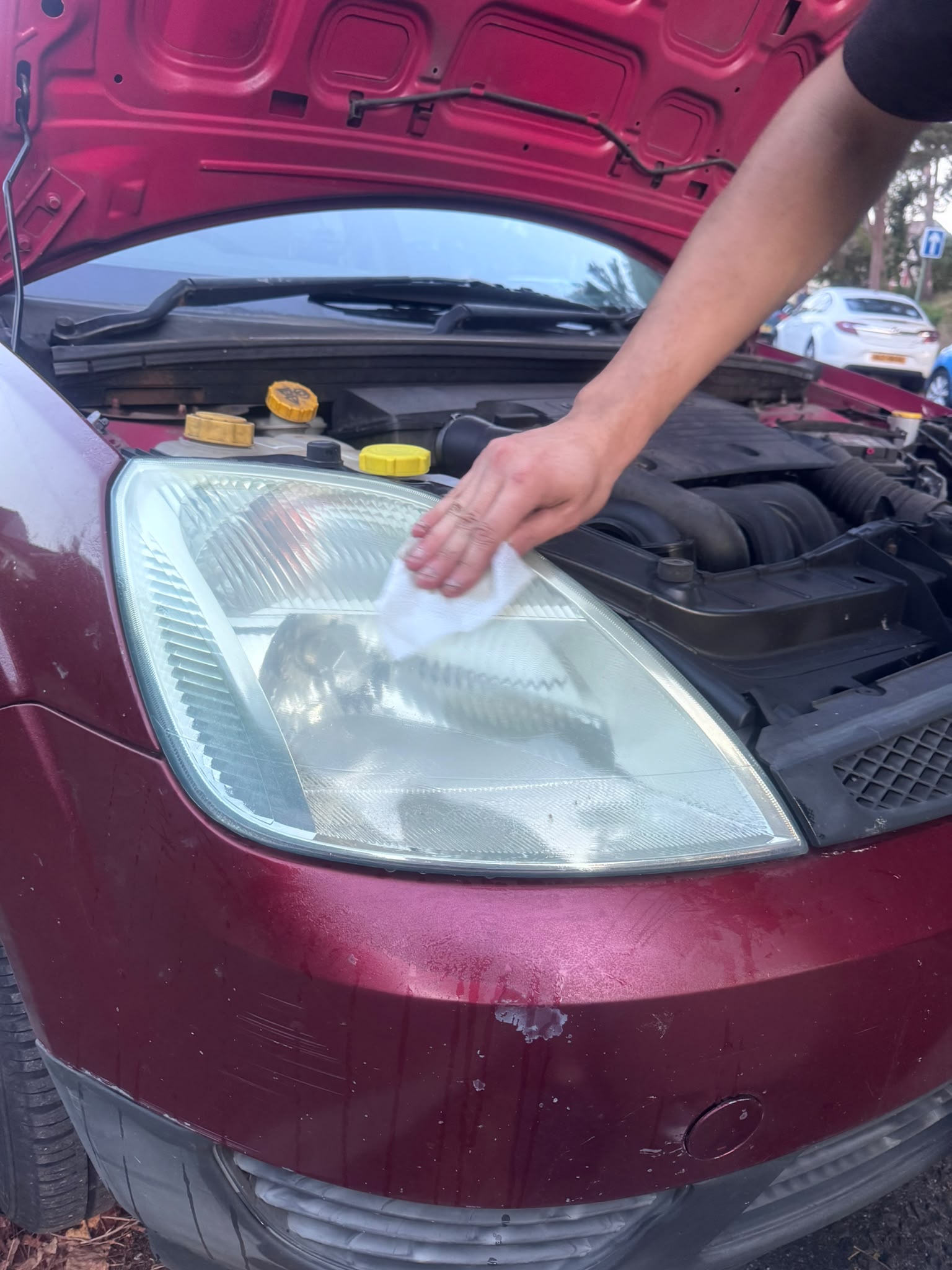 Technician machine polishing a car headlight